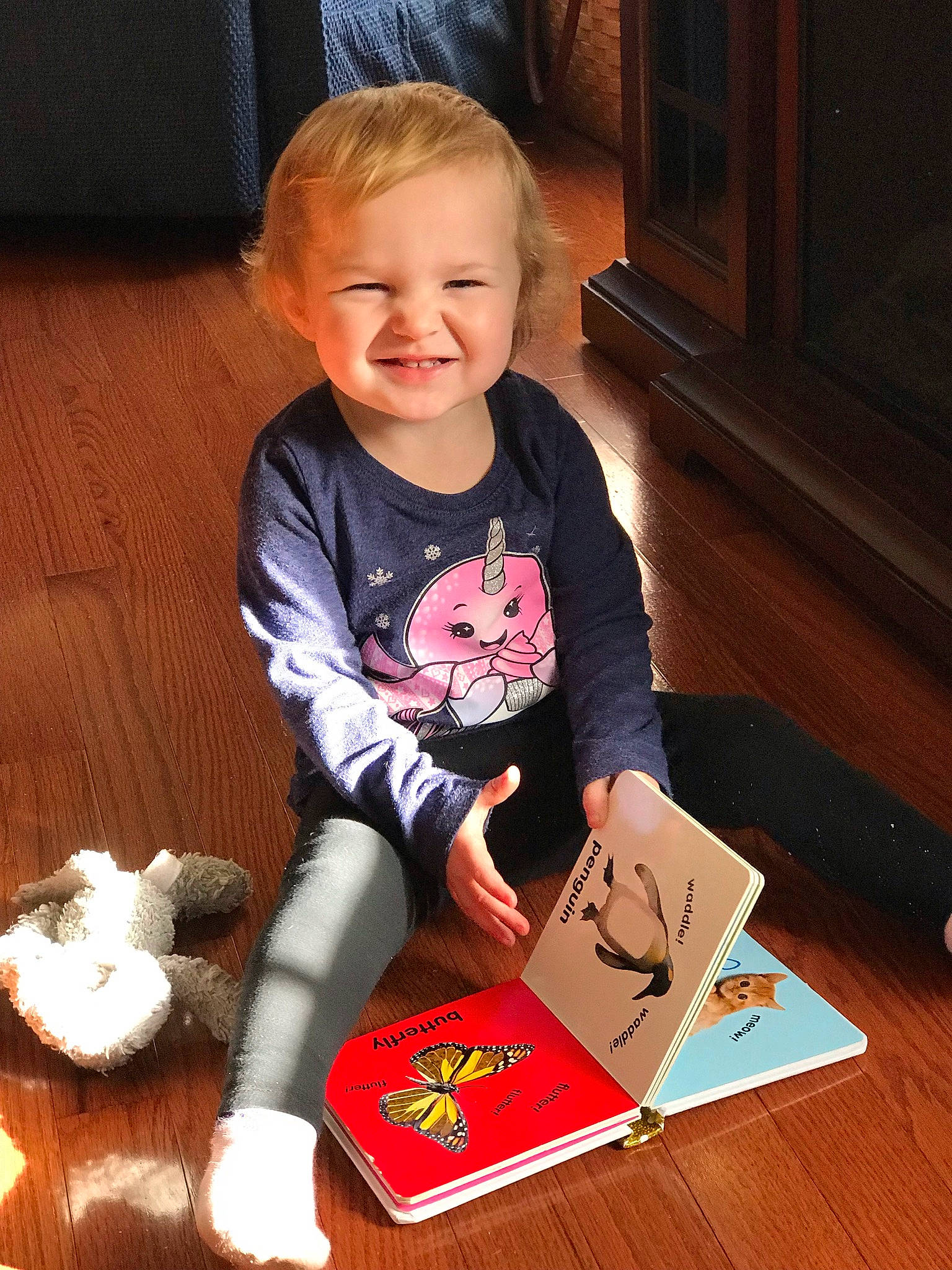 Miya joined the competition — help win amazing prizes! baby, baby_toddler_clothing, book, carmine, chair, child, eye, face, floor, flooring, hair, happy, hardwood, head, joy, person, sitting, sleeve, smile, t_shirt