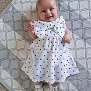 Ivy joined the competition — help win amazing prizes! baby, infant, smiling, dress, polka_dot, bow, blanket, carpet, footwear, socks, cute, happy, lying_down, child, portrait, indoors, texture, pattern, white, gray