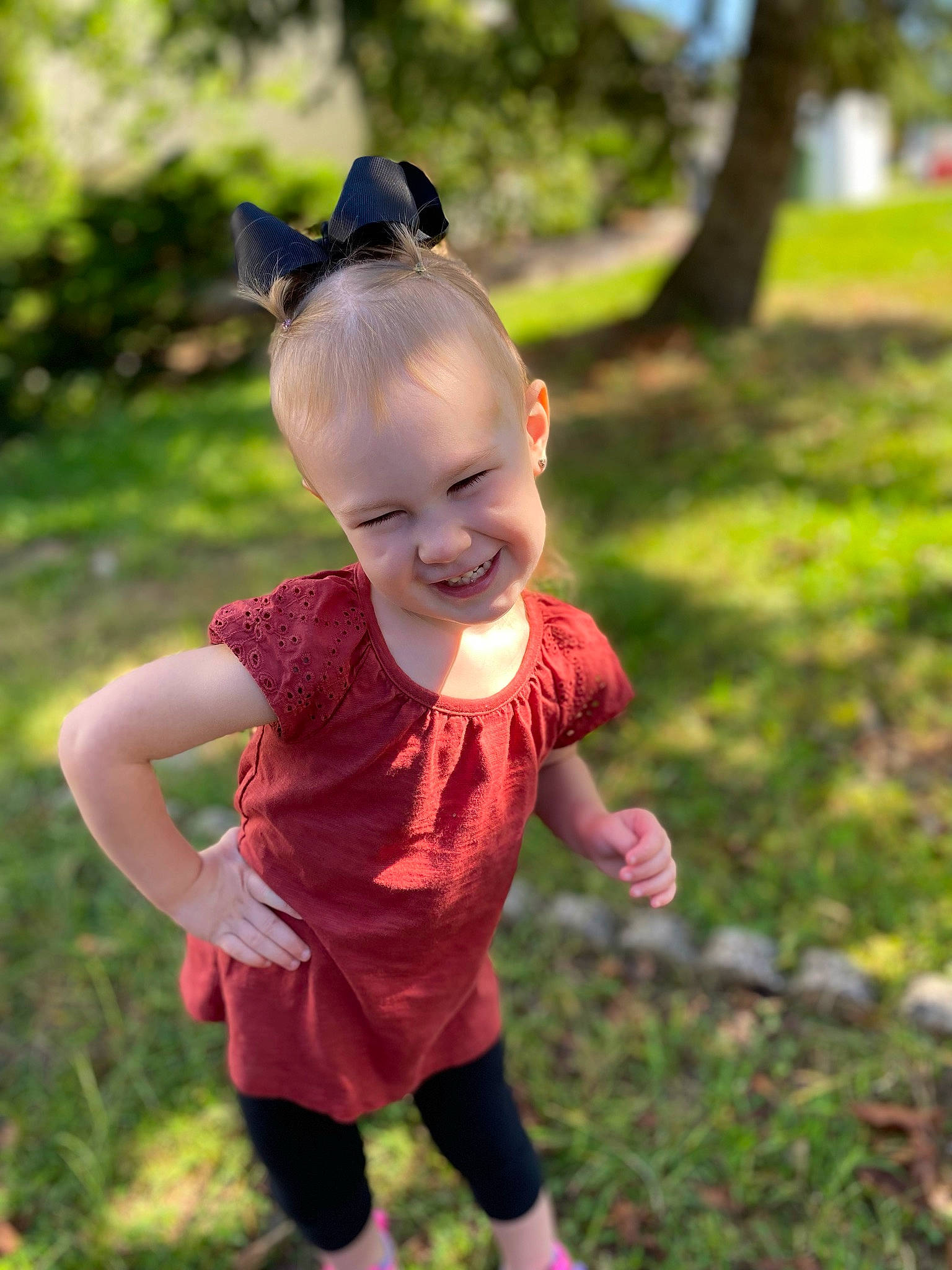Elaina joined the competition — help win amazing prizes! baby, baby_toddler_clothing, child, eyewear, grass, happy, joy, leisure, magenta, pattern, people_in_nature, person, personal_protective_equipment, pink, plant, recreation, sitting, smile, sunglasses, t_shirt