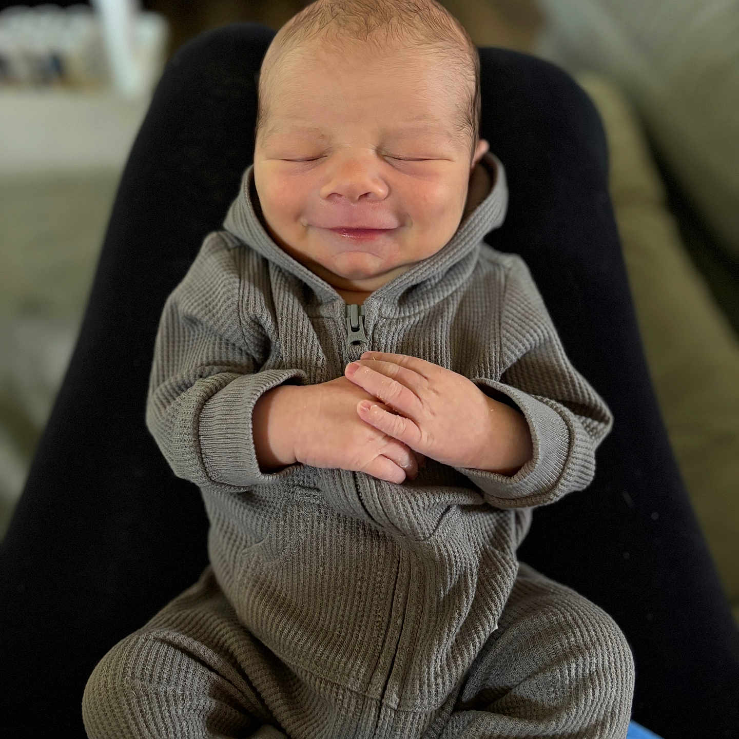 Renly is registered to the contest to win money with this photo: baby, bodypart, clothing, couch, face, finger, furniture, hand, happy, head, hoodie, knitwear, newborn, pants, person, photography, portrait, smile, sweater, sweatshirt