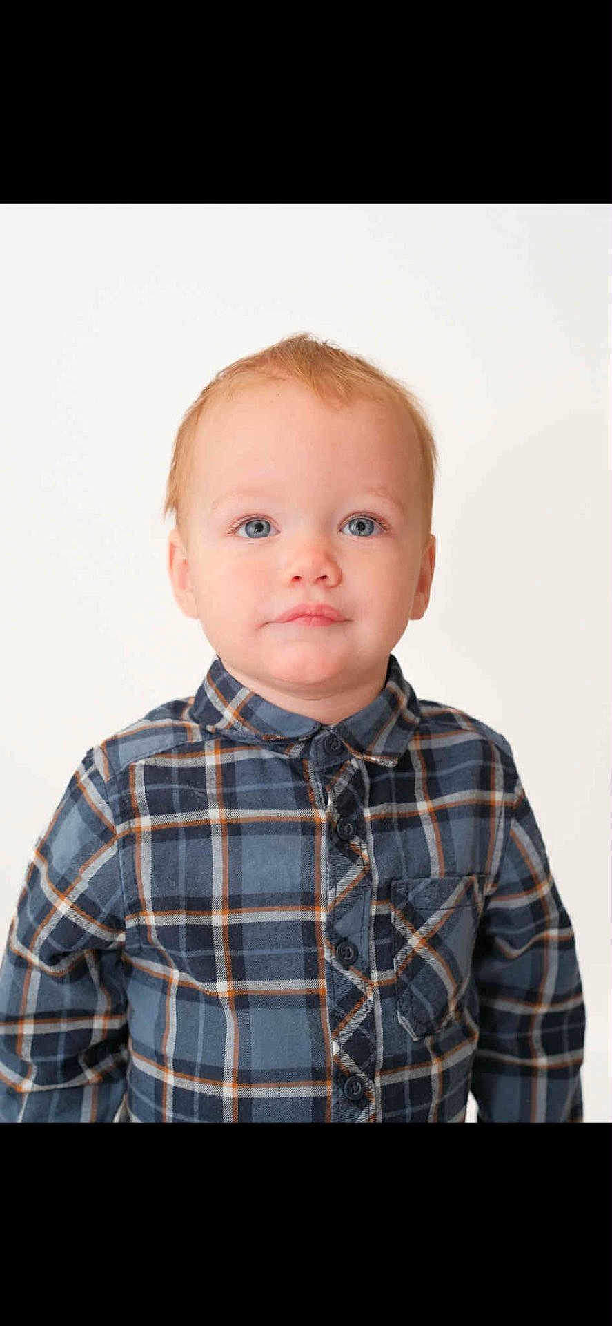 Oakley is registered to the contest to win money with this photo: toddler, child, portrait, blue_eyes, red_hair, plaid_shirt, casual_clothing, buttoned_shirt, young_child, innocence, studio_photo, white_background, curious_expression, face, person, head_and_shoulders, indoor, cute, smile, fashion