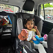 Ishika joined the competition — help win amazing prizes! child, car_seat, plush_toy, vehicle_interior, window, suburban, seatbelt, clothing, person, toy, hair, face, car, child_seat, sitting, safety, inside, daylight, expression, transportation