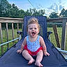 baby, child, smiling, happy, outdoor, lawn_chair, blue_sky, greenery, deck, wooden_railing, baby_clothes, tutu, sitting, face, person, summer, sunset, grass, fence, cute