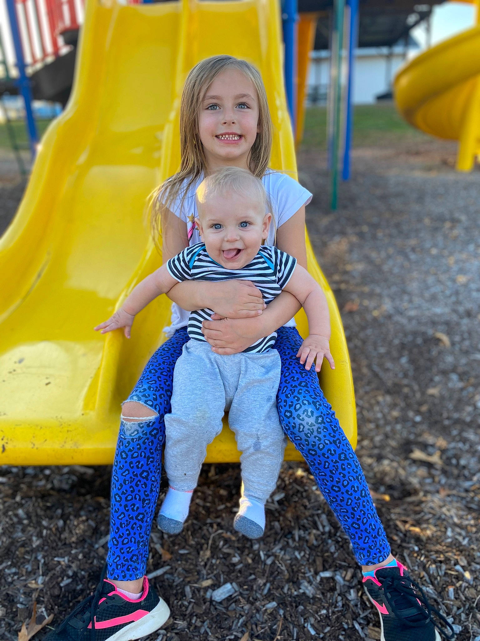 Aleana is registered to the contest to win money with this photo: baby_toddler_clothing, blue, dress, eye, face, footwear, fun, grass, hair, happy, joy, leisure, outdoor_recreation, people, person, plant, playground, shoe, smile, sneakers