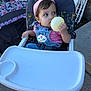 Leilani Veglia joined the competition — help win amazing prizes! toddler, child, high_chair, balloon, headband, denim_overalls, pink_shirt, outdoor, playpen, person, foot, concrete, folding_chairs, baby, seatbelt, hand, face, looking_away, toy, summer