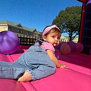 Leilani Veglia joined the competition — help win amazing prizes! toddler, child, baby, overalls, headband, pink, purple, balloons, inflatable, outdoor, daylight, sky, tree, building, crawling, play, fun, cute, person, summer