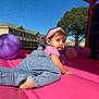 toddler, child, baby, overalls, headband, pink, purple, balloons, inflatable, outdoor, daylight, sky, tree, building, crawling, play, fun, cute, person, summer