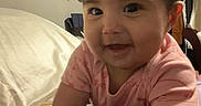 Camila is registered to the contest to win money with this photo: baby, infant, child, smiling, crawling, pink_clothing, toy, bed, indoor, trophy, face, person, happy, cute, closeup, young_child, home, furniture, sleepwear, play