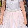 child, girl, dress, white_dress, blonde_hair, smiling, indoor, people, carpet, socks, happy, portrait, standing, curly_hair, event, background, wall_decor, fashion, cute, person