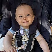 Luna participe au concours pour gagner de l'argent avec cette photo : baby, child, smiling, stroller, pacifier, clip, lion, light_blue_shirt, happy, infant, dimples, face, hand, black_straps, safety_harness, cute, portrait, seat, baby_accessory, comfort