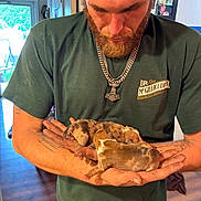 Sunna joined the competition — help win amazing prizes! affection, baby_dogs, beard, casual_clothing, cute, door, gentle, green_shirt, hands, holding, indoor, man, necklace, pet, puppies, sleeping, small_animals, tattoo, window, wood_floor