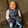 baby, child, smiling, suit, bow_tie, couch, glasses, happy, portrait, indoor, seated, clothing, fashion, person, face, cute, young, infant, textured, furniture
