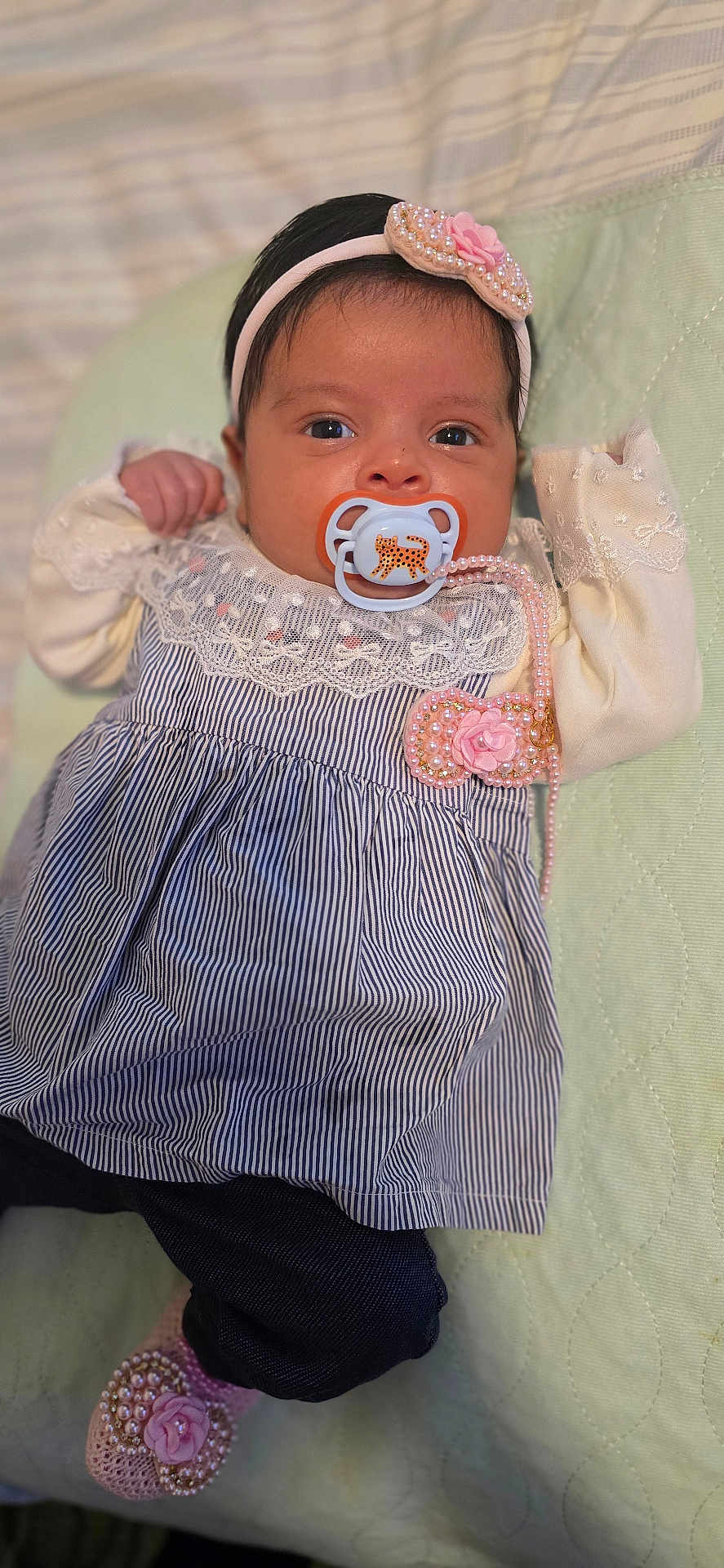 Anna joined the competition — help win amazing prizes! baby, infant, pacifier, headband, dress, lace, pink_accessories, hand, face, eyes, lying_down, clothing, footwear, bed, quilted_surface, cute, portrait, child, indoors, newborn
