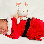 éloïse a rejoint le concours — aidez-le/la à gagner de superbes lots ! newborn, baby, sleeping, red_clothing, plush_toy, bunny, soft_texture, white_blanket, holiday_theme, cute, peaceful, infant, portrait, cozy, child, indoors, resting, christmas_outfit, toy, sleep