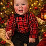 Nickeil joined the competition — help win amazing prizes! baby, smiling, plaid_shirt, bow_tie, suspenders, holiday, christmas, pine_branches, berries, lantern, lights, cozy, blanket, festive, indoors, cute, toddler, red, black, warm_lighting
