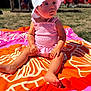 Elya a rejoint le concours — aidez-le/la à gagner de superbes lots ! barefoot, beach_towel, blurred_background, child, colorful, cute, daytime, grass, nature, outdoor, people, person, pink_dress, portrait, sitting, summer, sunhat, sunlight, toddler, young_child