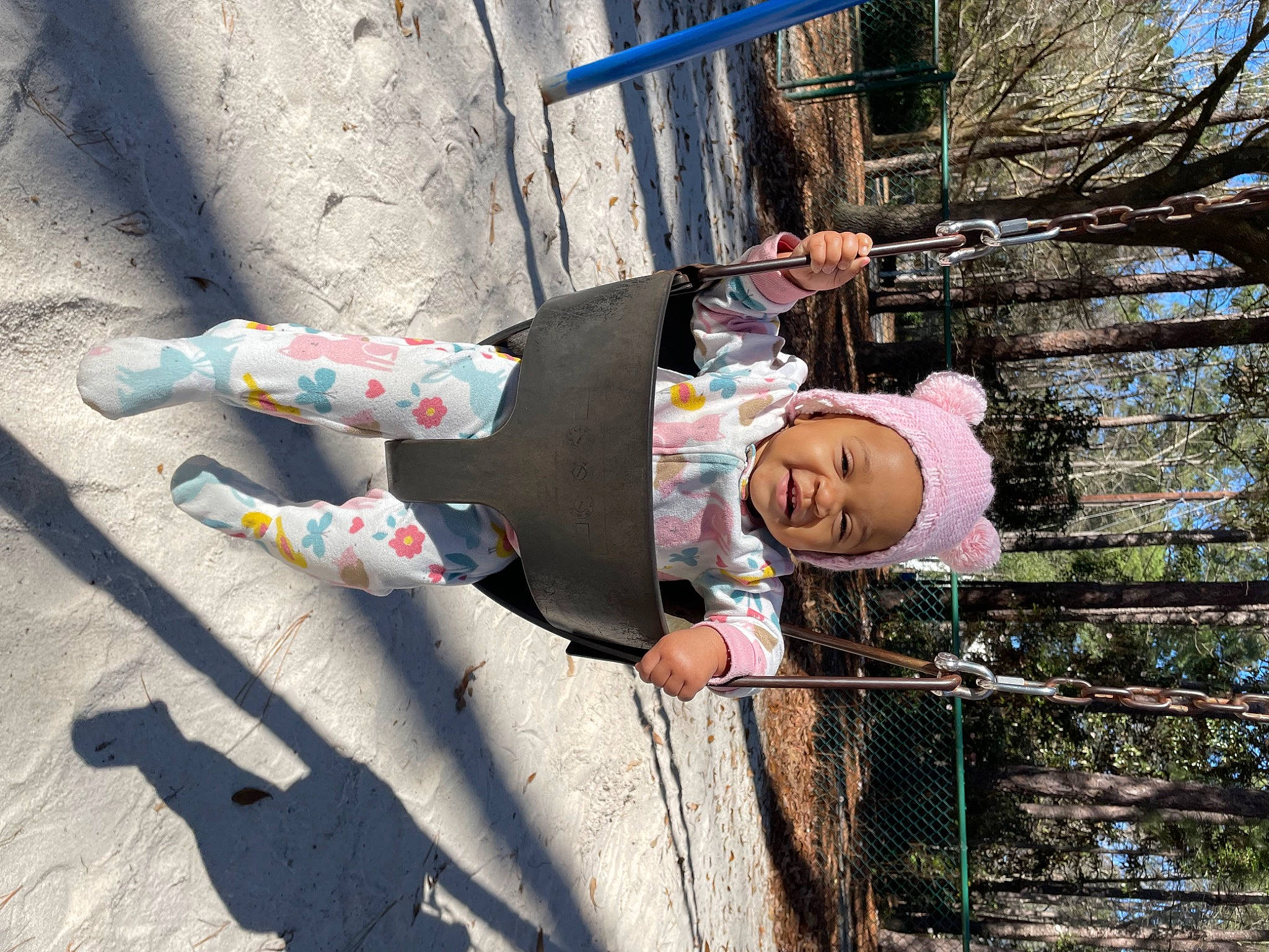 Alena is registered to the contest to win money with this photo: asphalt, child, concrete, fence, fun, happy, hat, headwear, leisure, person, recreation, road_surface, sky, smile, toddler, tree, wood