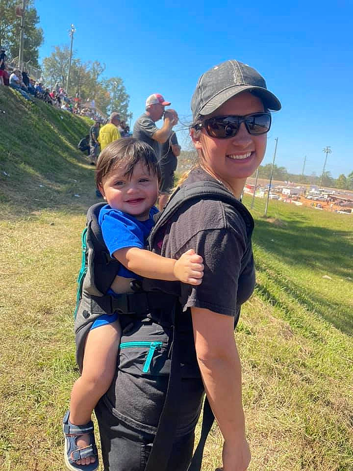 Triston is registered to the contest to win money with this photo: baseball_cap, cap, cool, eyewear, fun, goggles, grass, happy, headwear, joy, leisure, luggage_and_bags, mountainous_landforms, people_in_nature, person, plant, recreation, shorts, sky, smile