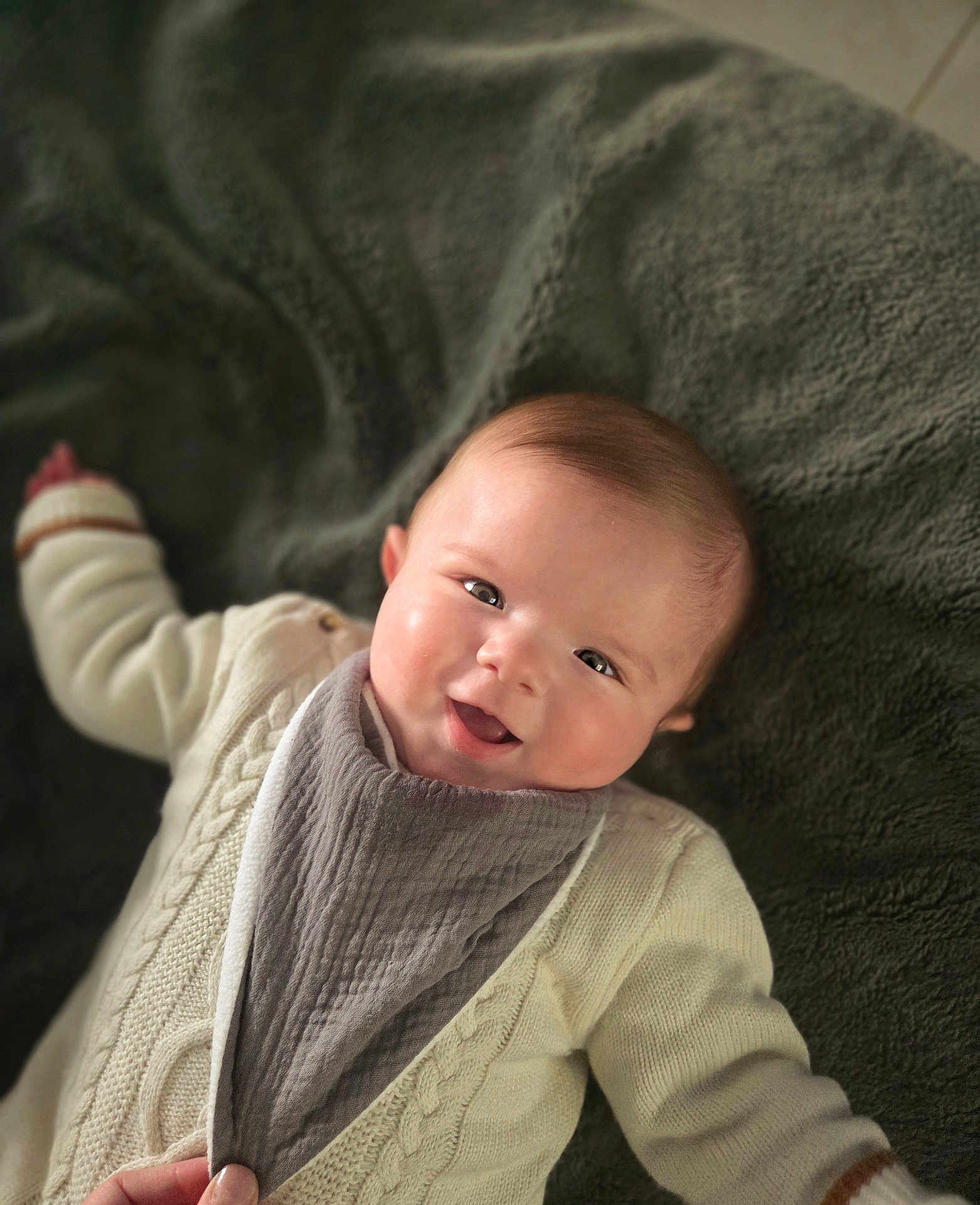 Marius participe au concours pour gagner de l'argent avec cette photo : baby, smiling, infant, blanket, cozy, sweater, bib, face, happy, child, cute, portrait, skin, cheeks, clothing, lying_down, young, indoors, person, warm