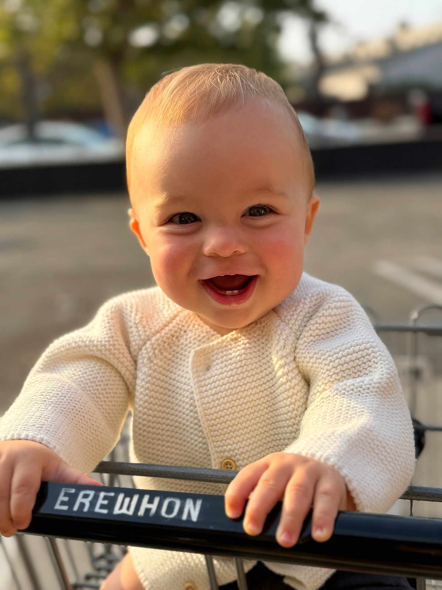 Raphaël a rejoint le concours — aidez-le/la à gagner de superbes lots ! baby, child, smile, happy, shopping_cart, knitted_sweater, hand, face, outdoor, parking_lot, daylight, person, clothing, blond_hair, cute, closeup, portrait, retail, infant, holding
