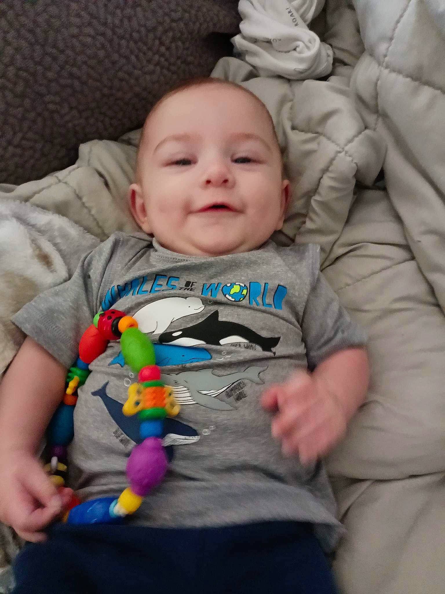 Chase is registered to the contest to win money with this photo: baby, baby_toddler_clothing, cheek, chin, comfort, eye, face, facial_expression, happy, head, iris, nose, outerwear, person, product, skin, sleeve, smile, standing, t_shirt