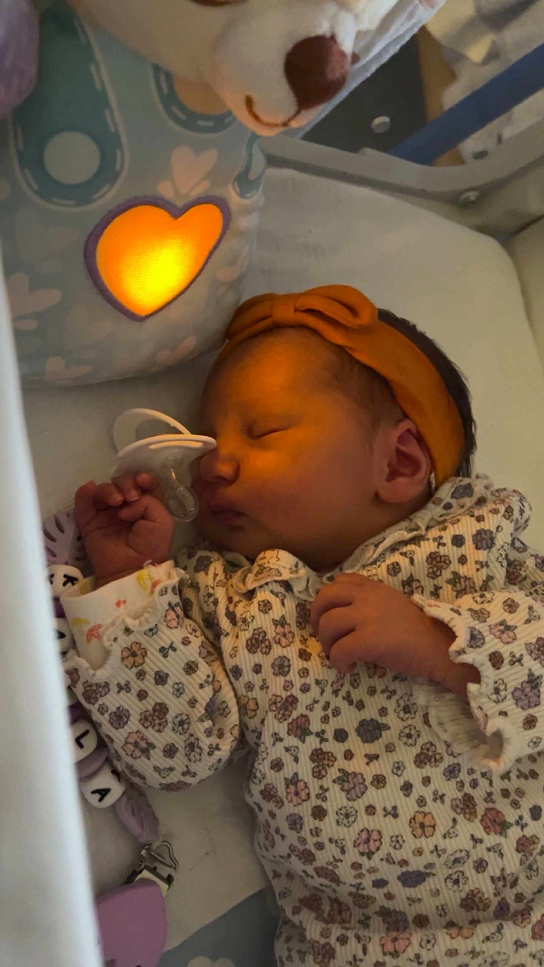 Kayla a rejoint le concours — aidez-le/la à gagner de superbes lots ! baby, sleeping, pacifier, headband, floral_outfit, stuffed_toy, glowing_heart, crib, blanket, hand, infant, peaceful, soft_lighting, bedtime, cute, child, indoor, cozy, nursery, toy