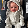 Walker is registered to the contest to win money with this photo: baby, infant, child, smile, tongue, hood, onesie, car_seat, safety_label, buckle, fabric, cozy, cute, portrait, closeup, seat, mittens, foot, happy, newborn