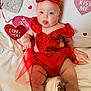 baby, infant, heart, valentine_decorations, red_dress, sequin, headband, bow, tongue_out, smiling, blanket, lying_down, cute, portrait, soft_texture, white_background, plush_hearts, love_you_sign, chubby_legs, holiday_photo