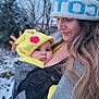 baby, woman, child, winter, snow, hat, knit_hat, pikachu_hood, outdoor, cold, nature, portrait, smile, baby_carrier, coat, long_hair, face, close_up, warm_clothing, bond