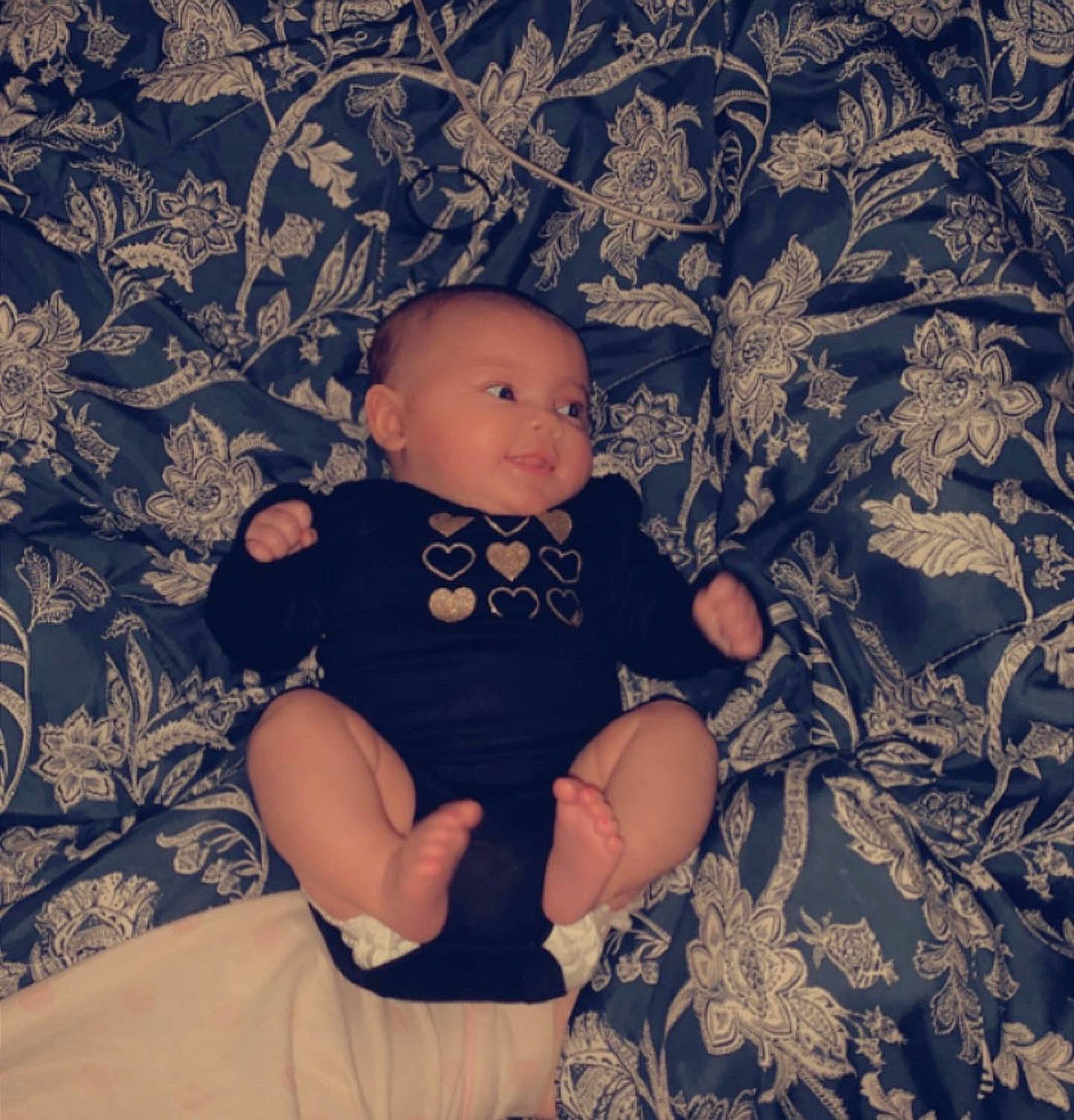 Oaklyn is registered to the contest to win money with this photo: baby, baby_toddler_clothing, child, comfort, doll, foot, happy, human_leg, linens, pattern, person, pink, room, sitting, skin, sleeve, t_shirt, thigh, tints_and_shades, toddler