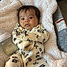 baby, infant, blanket, bottle, onesie, floral_pattern, face, person, indoor, cute, sleepwear, newborn, feeding, soft_texture, closeup, child, resting, baby_bottle, cozy, expression
