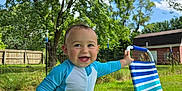 Ronald joined the competition — help win amazing prizes! toddler, child, smiling, outdoor, grass, tree, blue_suit, lawn_chair, sunny, daylight, fence, house, nature, happy, summer, play, baby, portrait, greenery, sky