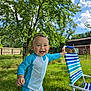 toddler, child, smiling, outdoor, grass, tree, blue_suit, lawn_chair, sunny, daylight, fence, house, nature, happy, summer, play, baby, portrait, greenery, sky