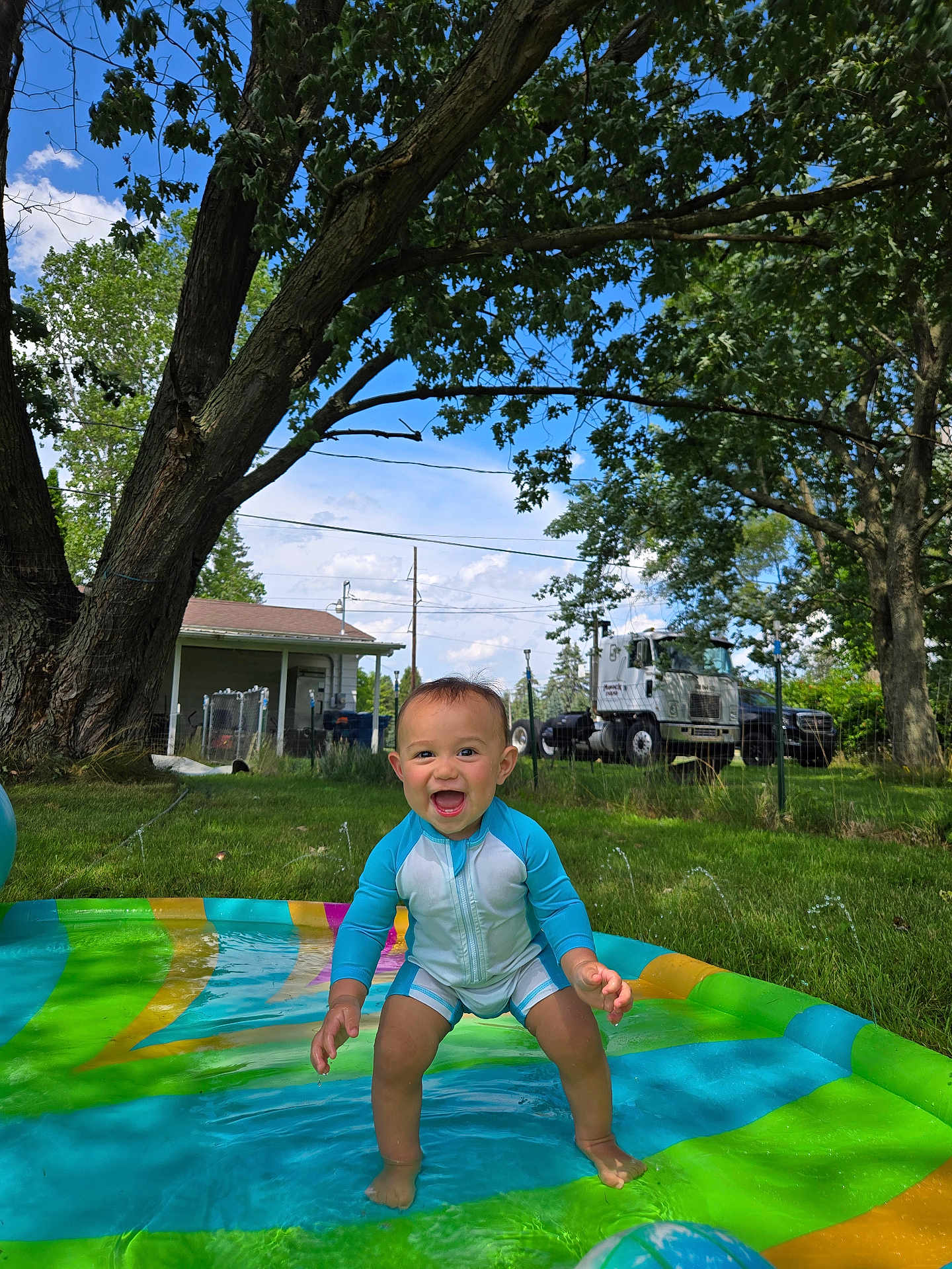 Ronald joined the competition — help win amazing prizes! toddler, child, pool, water, swimsuit, summer, outdoor, grass, tree, sky, cloud, house, truck, fence, play, happy, splash, greenery, daytime, smile