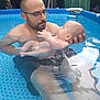 Livio participe au concours pour gagner de l'argent avec cette photo : baby, man, adult, child, swimming_pool, water, holding, backyard, glasses, beard, portrait, family, outdoor, summer, reflection, skin, pool_liner, parent_and_child, relaxation, tender_moment