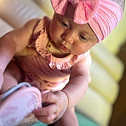 Cayetana a rejoint le concours — aidez-le/la à gagner de superbes lots ! baby, infant, child, pink, headband, bow, shoe, curious, couch, soft_focus, indoors, closeup, skin, hand, footwear, sitting, cute, portrait, young, exploring