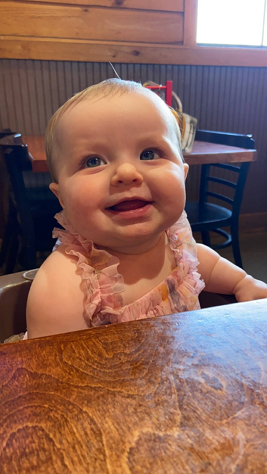 Maisie is registered to the contest to win money with this photo: baby, baby_toddler_clothing, chair, cheek, child, eyebrow, eyelash, flooring, fun, happy, hardwood, iris, joy, lip, nose, person, sitting, smile, table, thumb