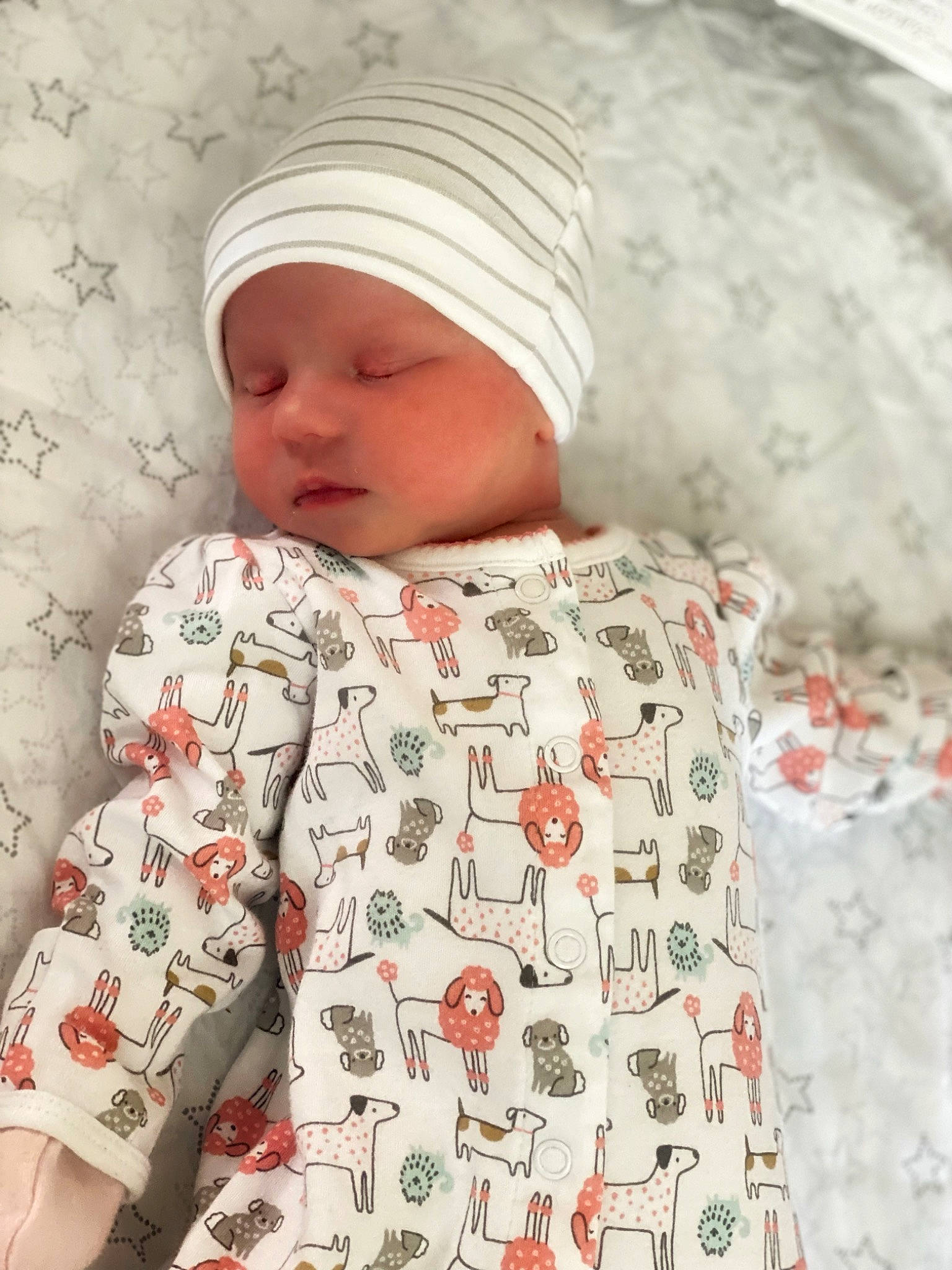 Ayvah is registered to the contest to win money with this photo: baby, baby_sleeping, baby_toddler_clothing, bedding, cap, carmine, child, collar, comfort, face, facial_expression, headwear, linens, outerwear, pattern, person, skin, sleeve, t_shirt, textile