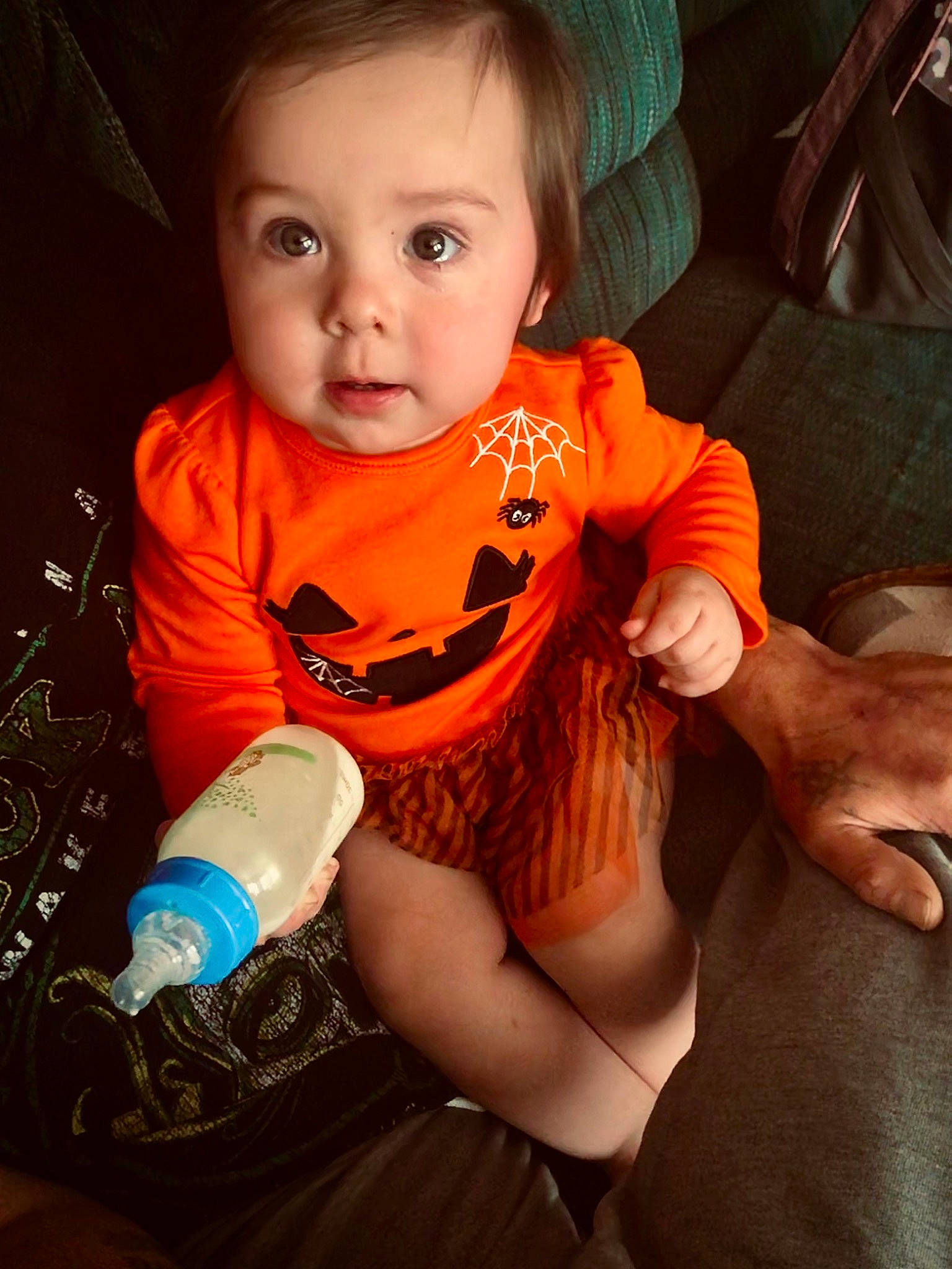 Kelly is registered to the contest to win money with this photo: arm, baby, baby_toddler_clothing, cheek, child, cool, drinkware, face, finger, hand, happy, head, nail, orange, person, plastic_bottle, skin, sleeve, t_shirt, toddler