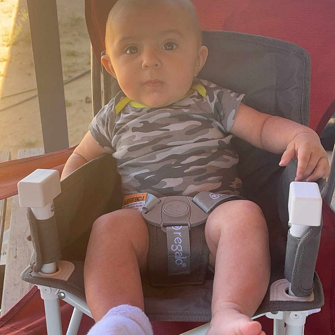 Jenson is registered to the contest to win money with this photo: architecture, baby, building, chair, clothing, cushion, face, furniture, head, homedecor, hosiery, outdoors, person, photography, portrait, shorts, sitting, sock, summer, t_shirt