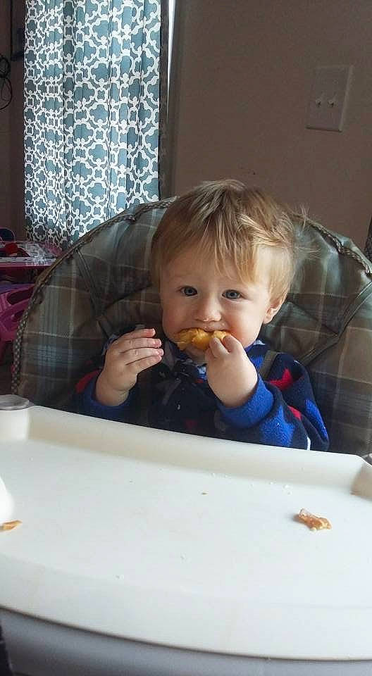 Michael is registered to the contest to win money with this photo: baby, cheek, child, eating, face, food, joy, nose, person, play, room, sitting, skin, toddler