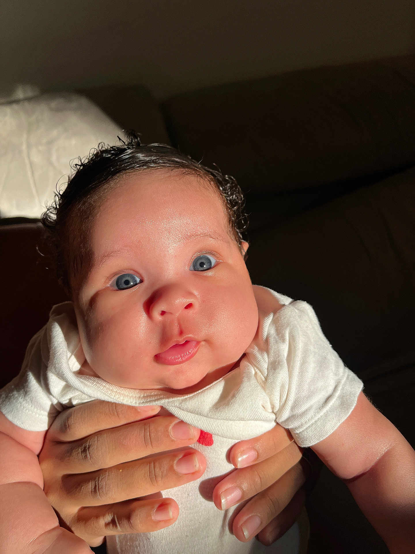 Imany a rejoint le concours — aidez-le/la à gagner de superbes lots ! baby, infant, hands, blue_eyes, white_clothing, cute, portrait, closeup, skin, child, person, indoor, light, shadow, natural_light, expression, face, newborn, human, holding
