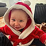 Taha a rejoint le concours — aidez-le/la à gagner de superbes lots ! apparel, baby, blanket, child, cozy, cute, face, furniture, headwear, hood, indoor, infant, joyful, person, red_clothing, room, sitting, smile, soft_texture, warm_clothing