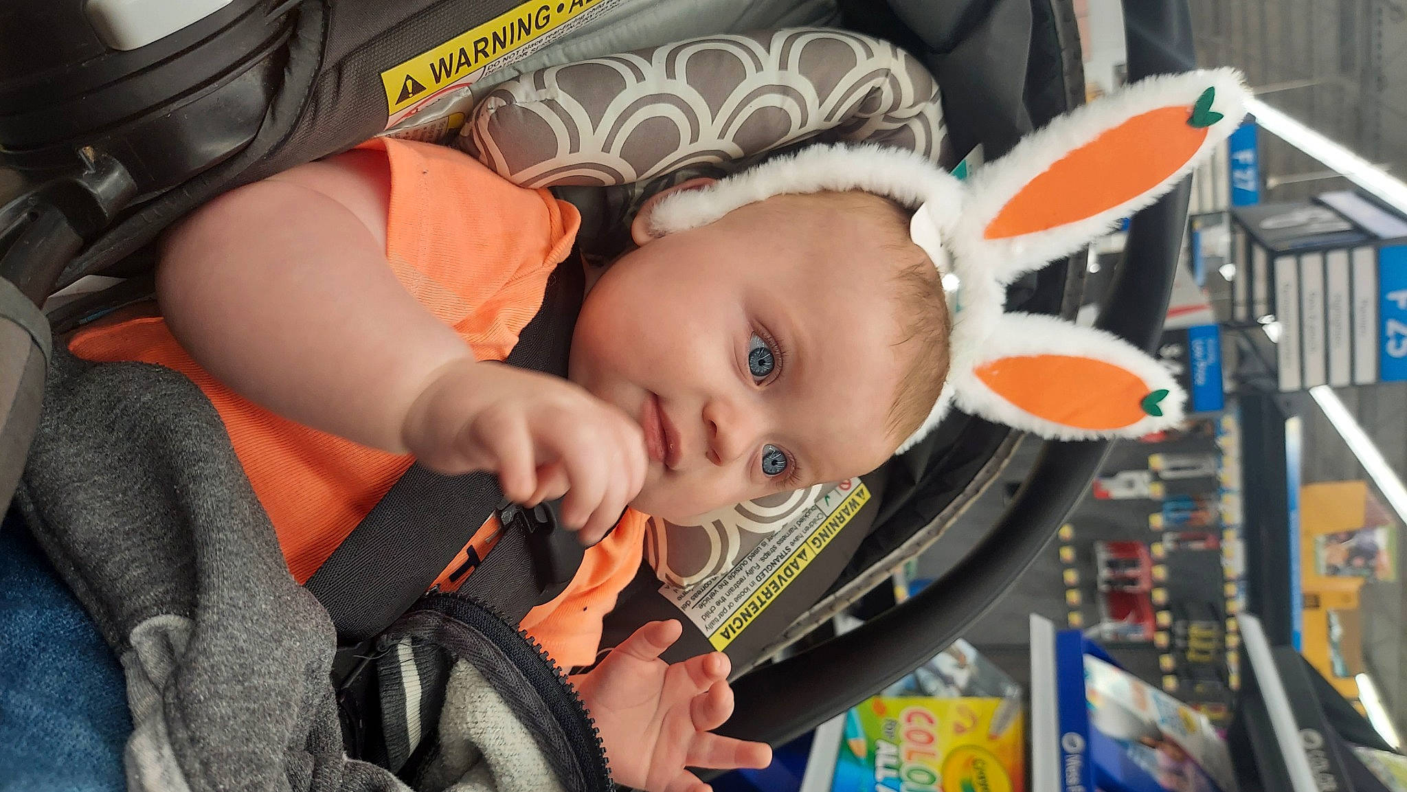 Jett is registered to the contest to win money with this photo: audio_equipment, auto_part, baby, baby_carriage, baby_products, baby_safety, baby_toddler_clothing, car_seat, cheek, child, comfort, ear, eye, fun, iris, orange, person, personal_protective_equipment, steering_wheel, toddler