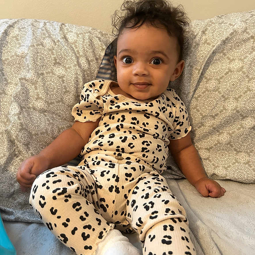 Ariya joined the competition — help win amazing prizes! baby, child, clothing, comfortable, cushion, cute, expression, face, hair, indoor, infant, leopard_print, pattern, person, portrait, relaxed, seated, skin, smiling, socks