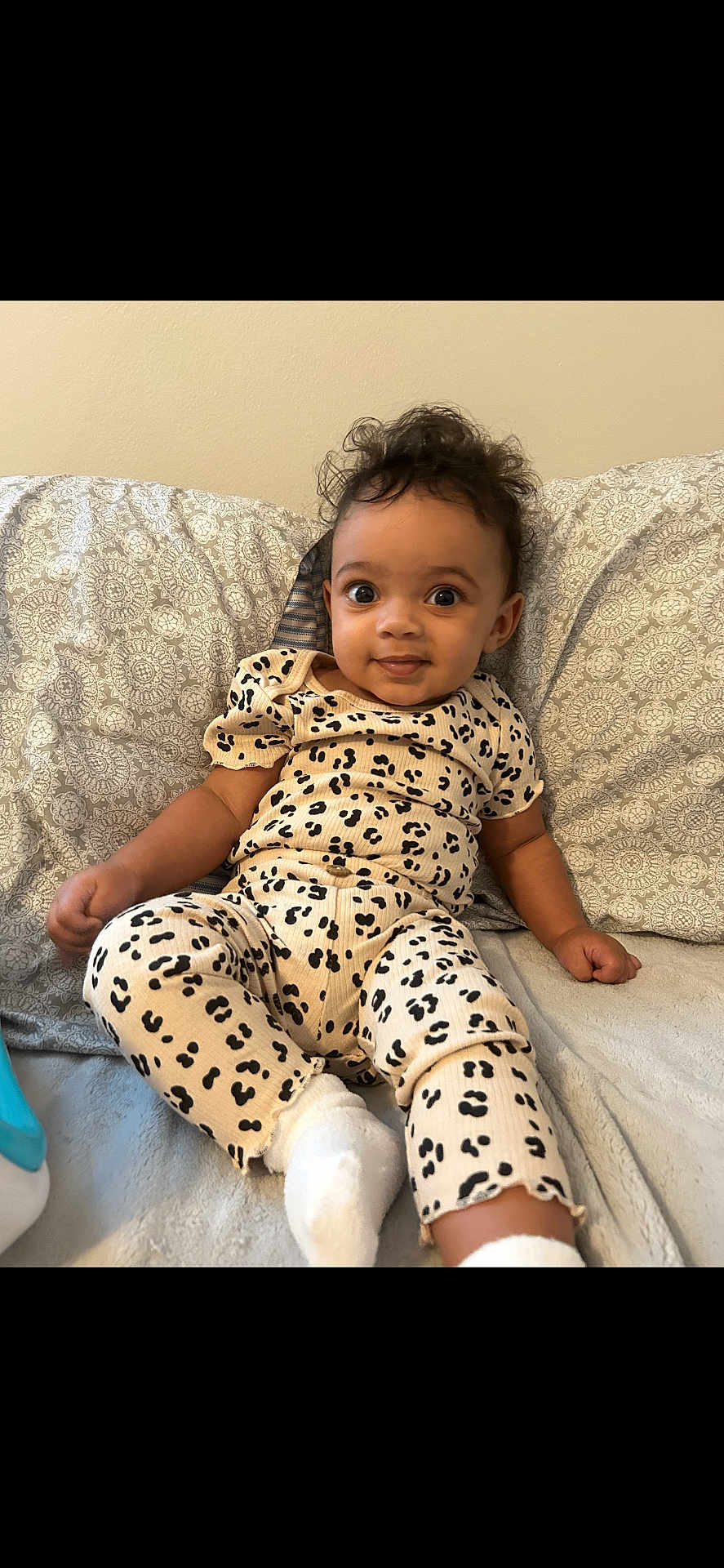 Ariya joined the competition — help win amazing prizes! baby, infant, child, cute, smiling, leopard_print, clothing, socks, cushion, pattern, indoor, portrait, person, face, hair, skin, seated, relaxed, comfortable, expression