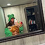 bathroom, cabinet, casual, cat, faucet, green_clothing, hoodie, indoor, long_hair, mirror, orange_cat, person, phone, reflection, selfie, sink, smudged_mirror, soap_dispenser, toiletries, wooden_wall