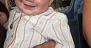 Cesar Mateo Morales is registered to the contest to win money with this photo: toddler, child, smile, striped_shirt, jeans, indoor, hand, adult, furniture, blue_chair, portrait, person, casual_clothing, happy, cute, face, people, background, holding, jewelry