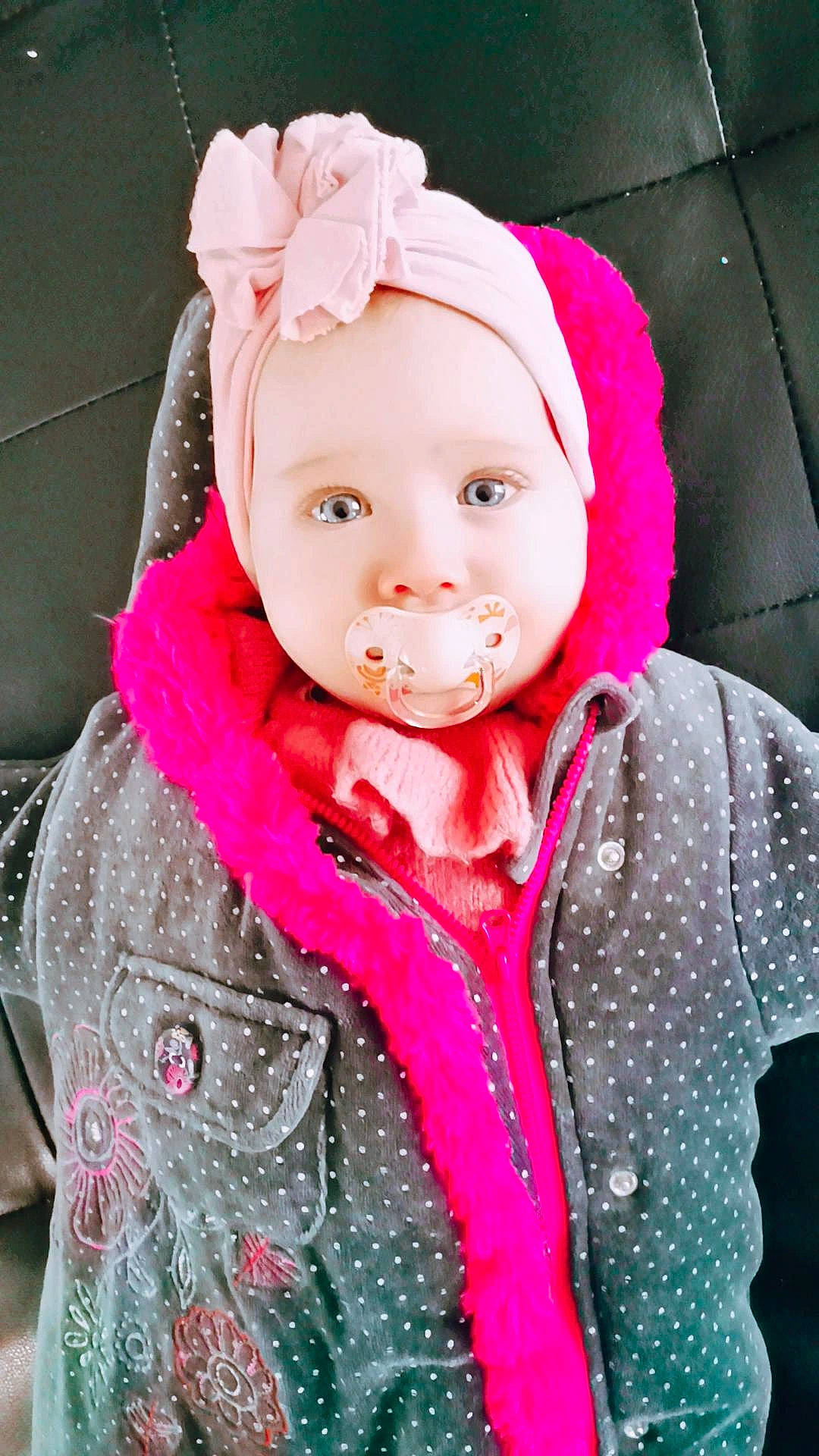 Tïa participe au concours pour gagner de l'argent avec cette photo : baby_toddler_clothing, cap, cheek, clothing, collar, dress, eye, eyelash, happy, head, headwear, human_body, jacket, lip, magenta, nose, outerwear, person, pink, skin