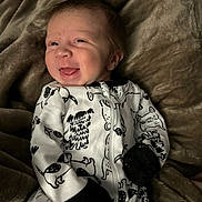 Asher joined the competition — help win amazing prizes! baby, infant, smile, onesie, dog_pattern, blanket, cozy, cute, face, lying_down, black_and_white_clothing, soft_texture, happy, tongue_out, newborn, child, portrait, warm, sleepwear, closeup